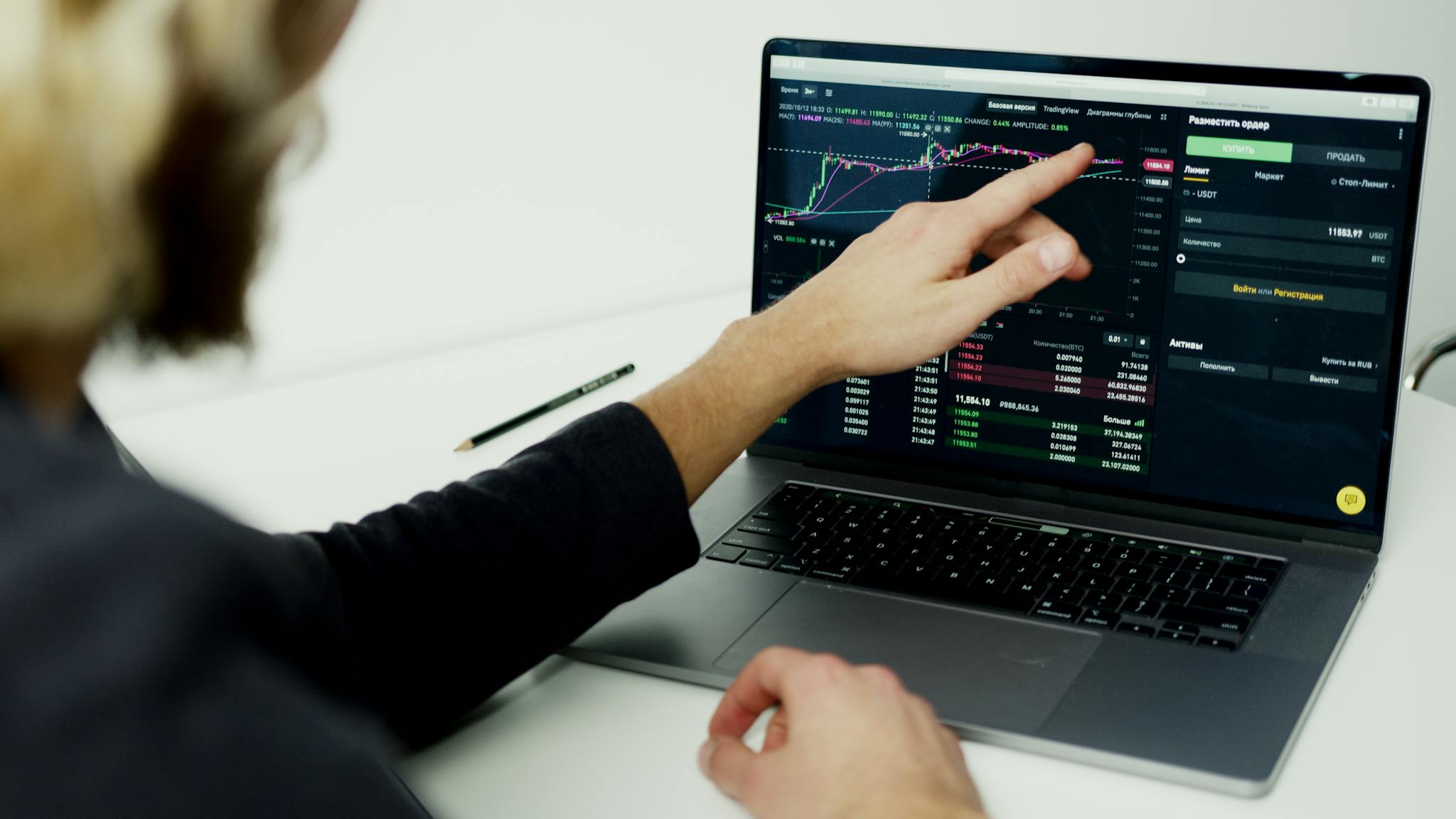 A person analyzing stock market graphs on a laptop screen, showcasing trading insights.